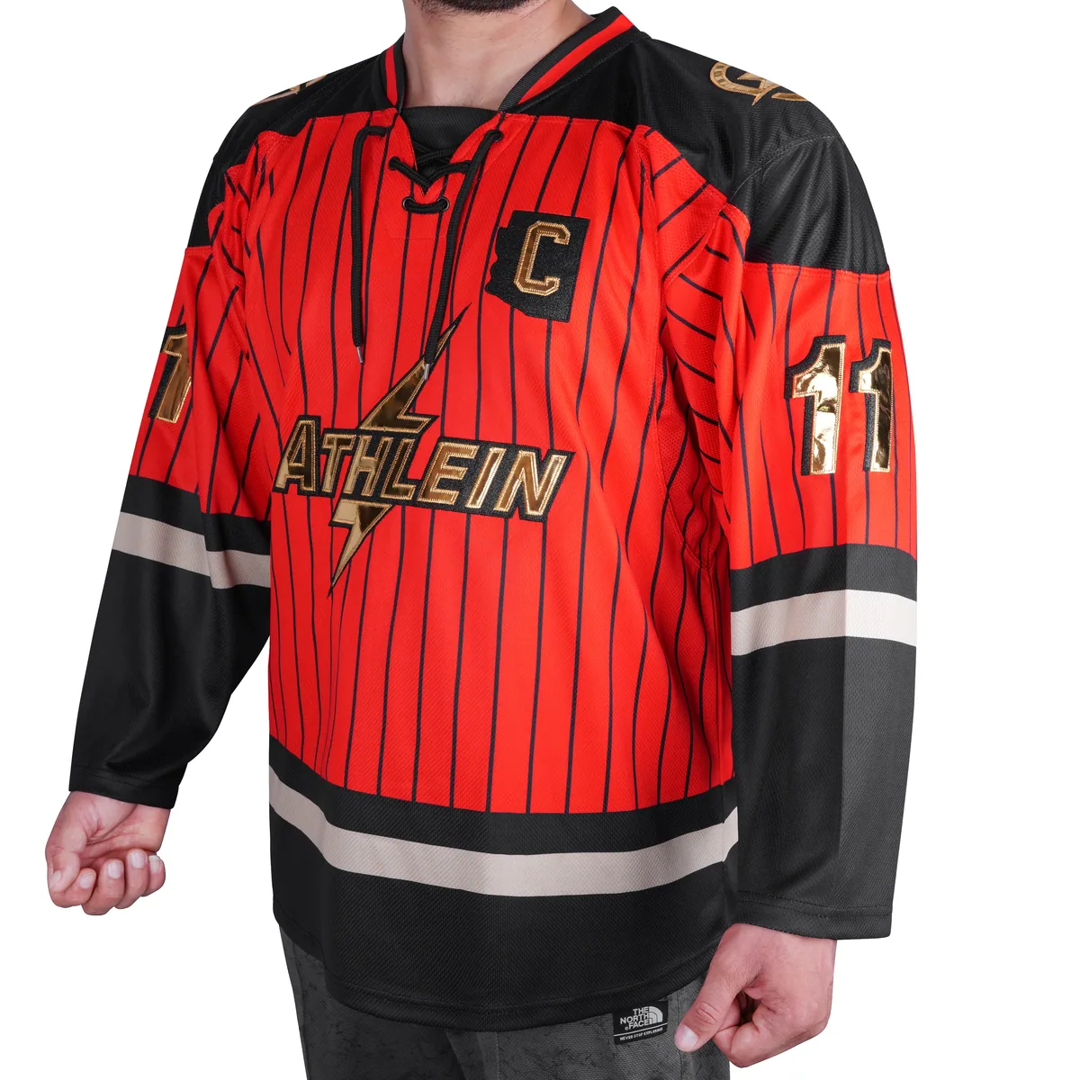 Red pinstripe ATHLEIN hockey jersey with lace-up collar, gold crest and captain letter